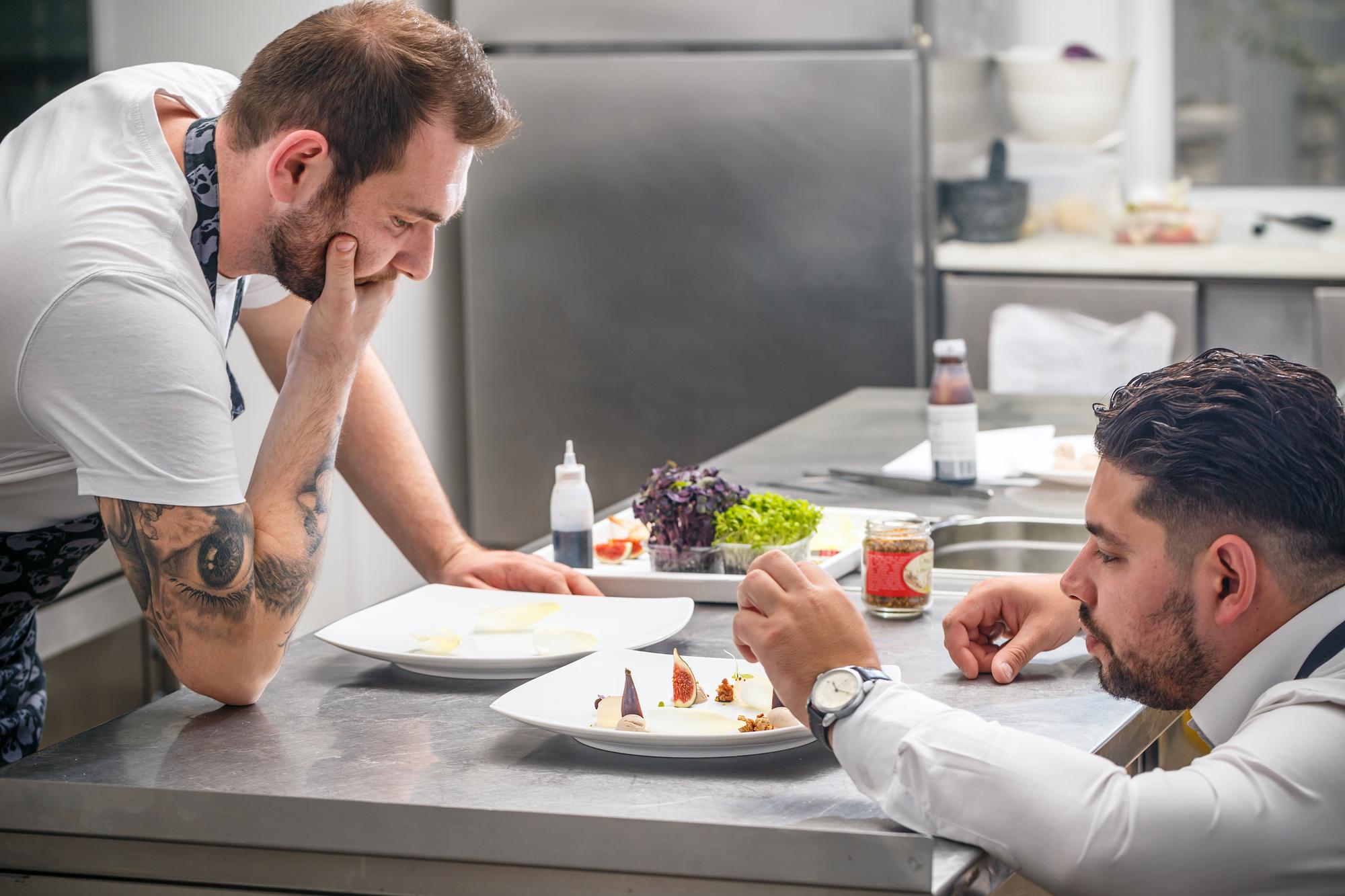 Chef consulting with client over plated dishes